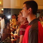 student at convocation holding lit candle