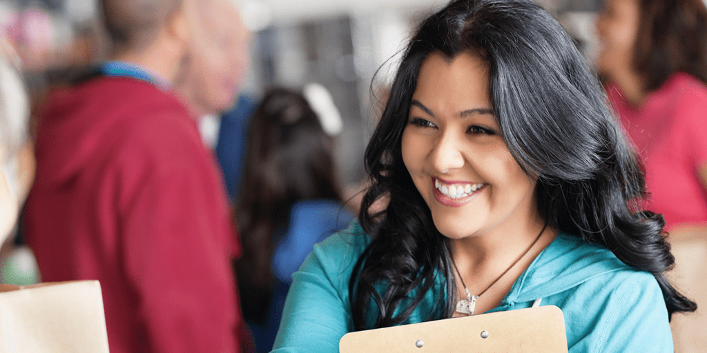 smiling female holding a clipboard